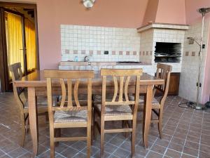 cocina con mesa de madera y sillas en Villa Stazzu Sa Murta, en Cugnana