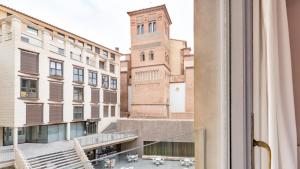 een uitzicht vanuit een raam van een gebouw met een klokkentoren bij Balcon del Torico in Teruel