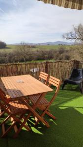 a wooden picnic table and two chairs on the grass at La Maison de Boyeux in Châtillon