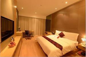 1 dormitorio con 1 cama grande y TV en Si Lin Apartment, en Guangzhou