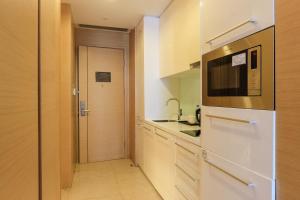 uma cozinha com um frigorífico branco e um micro-ondas em Si Lin Apartment em Guangzhou