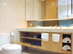 a bathroom with a sink and a toilet with towels at Si Lin Apartment in Guangzhou