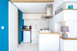 una cocina con armarios blancos y una puerta azul en Hauzify I Loft Brisa del Mar, en L'Ametlla de Mar