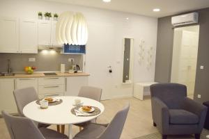 een keuken en eetkamer met een witte tafel en stoelen bij Anastasia Apartments & Rooms - Zagreb Centre in Zagreb