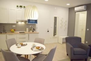 a kitchen and dining room with a white table and chairs at Anastasia Apartments & Rooms - Zagreb Centre in Zagreb