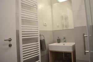 een witte badkamer met een wastafel en een spiegel bij Anastasia Apartments & Rooms - Zagreb Centre in Zagreb