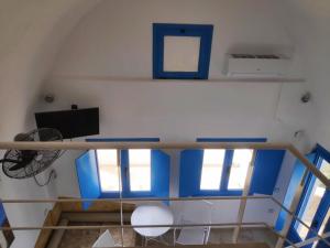 a room with blue and white walls and windows at Villa Aigli in Anafi