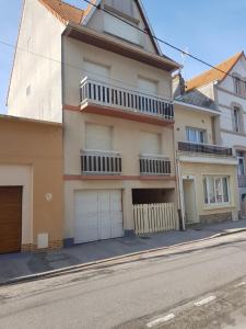 un bâtiment avec deux portes de garage dans une rue dans l'établissement Residence JEANNE 50 m de l'Esplanade classé 2 étoiles, à Berck-sur-Mer