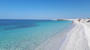 una playa de arena blanca y agua azul en Casa Marcy, en Oristano