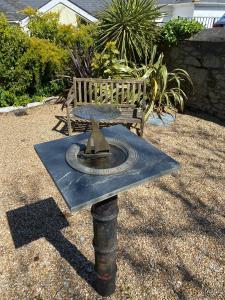 a statue of a bird bath with a bench at The Old English Rooms in Falmouth