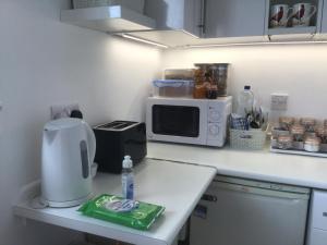 a kitchen with a counter top with a microwave at Eildon in Menai Bridge