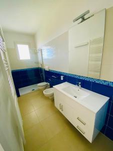 a bathroom with a sink and a toilet and a mirror at Vespucci Apartments Torre Lapillo in Torre Lapillo +29 photos