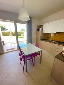 a kitchen and dining room with a table and chairs at Vespucci Apartments Torre Lapillo in Torre Lapillo