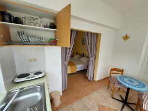a small kitchen with a sink and a room with a bed at Courtyard Studios in Pefki Rhodes