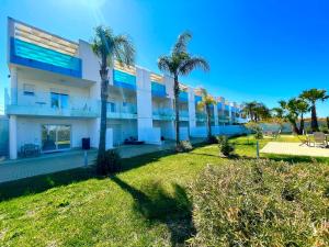 an exterior view of a building with palm trees at Vespucci Apartments Torre Lapillo in Torre Lapillo
