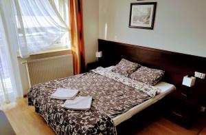 1 dormitorio con 1 cama con 2 toallas en Willa Latarnik - dokonała lokalizacja, blisko atrakcji, 20min do plaży en Łeba