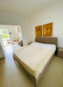 a bedroom with a large white bed in a room at Vespucci Apartments Torre Lapillo in Torre Lapillo