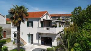 an aerial view of a white house with a palm tree at Apartman Tradicija in Kaštela