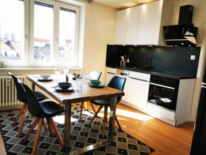 a kitchen with a table and chairs and a kitchen with a stove at Charmante Zentrumswohnung mit Balkon und 80 zoll TV in Klagenfurt