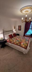 a bedroom with a large bed and a chandelier at Belvedere House in Middleton in Teesdale