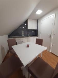 a white table and chairs in a small kitchen at Apartman Djokovic in Mokra Gora