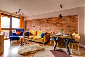 a living room with a couch and a brick wall at Krynica Apartamenty Centrum Deptak 45 in Krynica Zdrój