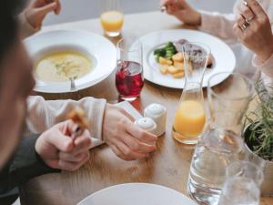 un grupo de personas sentadas en una mesa comiendo comida en ibis Hotel Eisenach, en Eisenach