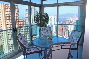 einen Tisch und Stühle auf einem Balkon mit Stadtblick in der Unterkunft 2-bedroom apartment in Torre Lúgano 58 in Benidorm