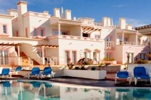 uma casa grande com piscina e cadeiras azuis em Luxury private property-pool, unique sun roof, free wifi em Budens