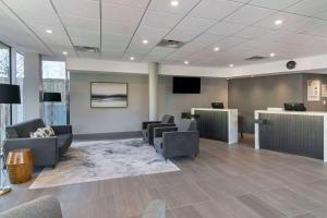 a waiting room with couches and chairs and a television at Quality Inn in Nanaimo