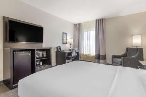 um quarto de hotel com uma cama e uma televisão de ecrã plano em Comfort Inn & Suites Greer - Greenville em Greer