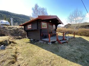 a small cabin with a table in the grass at Kvila Hytteutleie in Garmo