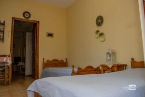 a bedroom with two beds and a clock on the wall at Eirini Kasimiotou Apartments in Agios Andreas