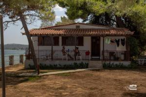 a house with two people sitting on the balcony at Eirini Kasimiotou Apartments in Agios Andreas