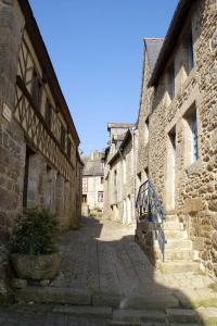 an alley in an old stone building with a bench at Gîte Charbonnerie in Moncontour
