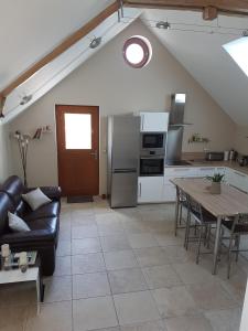 cocina y sala de estar con mesa y sofá. en Gîte Les Nymphéas, en Épeigné-les-Bois