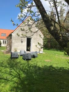budynek ze stołami i krzesłami na dziedzińcu w obiekcie Landlig idyl - direkte til golfbane w mieście Slagelse