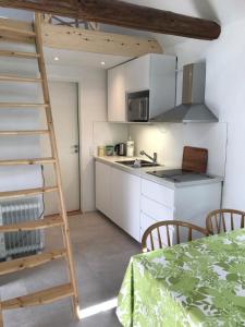 a kitchen with white cabinets and a ladder in a room at Landlig idyl - direkte til golfbane in Slagelse