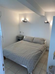 1 dormitorio con 1 cama y 2 luces en la pared en Location gîte campagne en Provence - Vaucluse, en Pernes-les-Fontaines