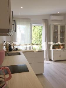 a kitchen with white cabinets and a large window at Studio proche mer et ville TOULON 2 pers in Toulon