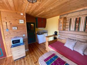 a room with a bed and a kitchen in a cabin at Kvila Hytteutleie in Garmo