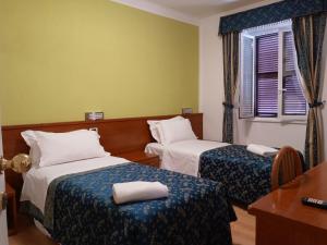 um quarto de hotel com duas camas e uma janela em La Casa Dell'Arte srl em Roma