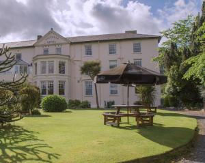 an umbrella and a picnic table in front of a building at Royal Victoria Hotel Snowdonia in Llanberis