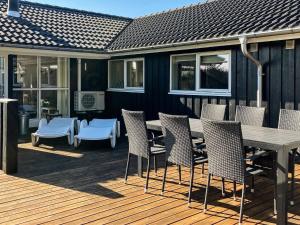 un patio con mesa y sillas en una terraza en 8 person holiday home in L kken, en Løkken
