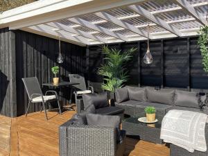 un patio con sofá, sillas y mesa en 8 person holiday home in L kken, en Løkken