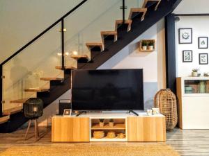 a living room with a tv and a staircase at Loft Porte Sud in Olhão