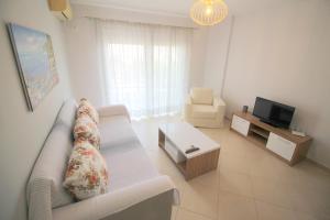 ein Wohnzimmer mit einem Sofa und einem TV in der Unterkunft Kosta's Apartment in Sarandë