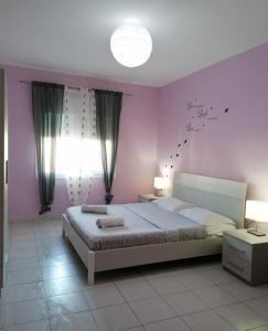 ヴロラにあるVilla zamos the bestのピンクの壁のベッドルーム1室(大型ベッド1台付)