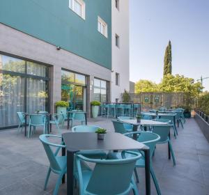 eine Reihe von Tischen und Stühlen auf einer Terrasse in der Unterkunft Hotel Venture Sant Cugat in Sant Cugat del Vallès