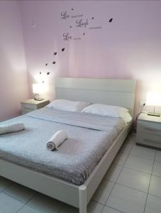 ヴロラにあるVilla zamos the bestのベッドルーム1室(壁に文字が付いたベッド1台付)